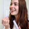 Femme dans la salle de bain avec le stick de blanchiment Diamond Smile dans la main