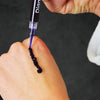 Gel de blanchiment des dents violet sur la main de Diamond Smile