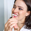 Femme se brossant les dents avec la poudre Diamond Smile PAP+ pour le blanchiment des dents