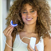Femme avec embout de blanchiment Diamond Smile Power+ Phone Rail LED dans la main