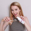 Femme avec la mousse de blanchiment Diamond Smile et une brosse à dents dans la main