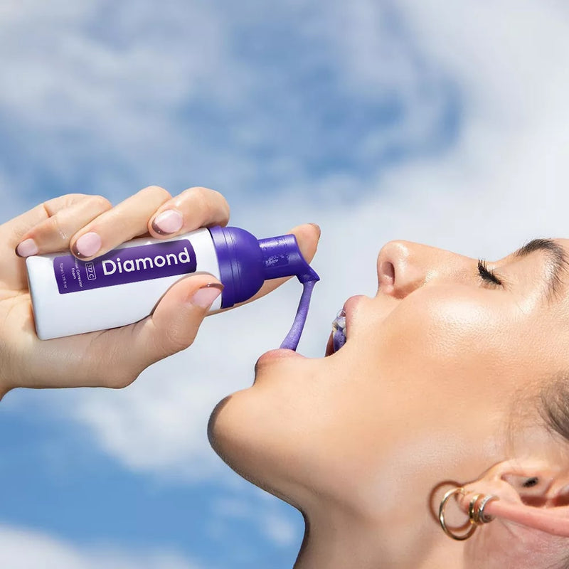 Femme avec Diamond Smile Lila blanchiment des dents correction de la couleur mousse dans la main