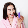 Femme avec Diamond Smile blanchiment des dents lilas - sérum de correction de la couleur dans la main