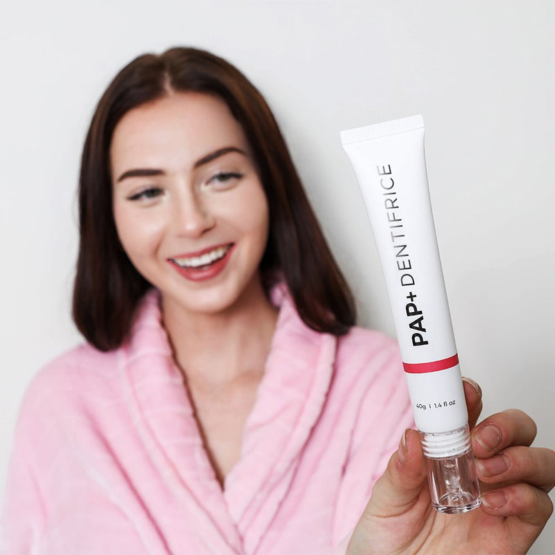 Femme utilisant le dentifrice blanchissant PAP+ de Diamond Smile